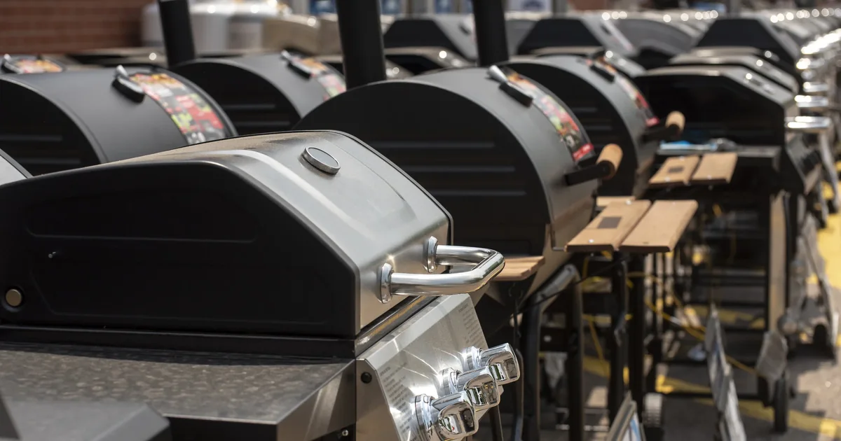 A row of outdoor smokers and grills in different styles