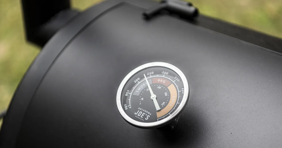 A black smoker lid with a round temperature gauge